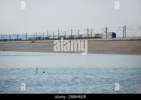 A class TEP 70 diesel locomotive with oil tanker wagons on the hydroelectric dam of Bratsk, Russia. This the BAM railway line, Baikal Amour Magistral. Stock Photo