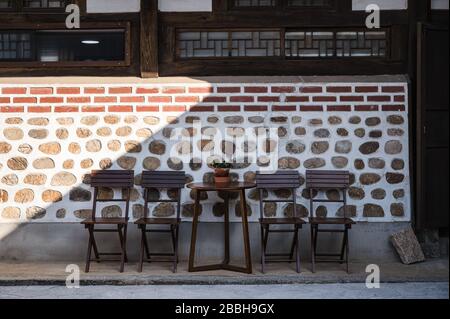 Wooden table and chairs on brick wall in traditional cafe Stock Photo
