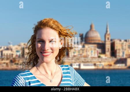 Happy young redhead woman tourist visiting Valletta, Malta Stock Photo
