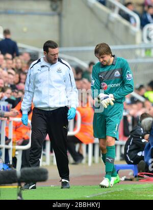 Newcastle United goalkeeper Tim Krul (right) is helped off the pitch as he has to be substituted due to a injury Stock Photo