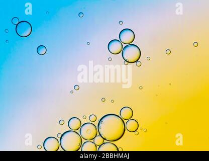 Abstract Background of Oil Bubbles on Water Surface Cyan Orange palette. Macro close-up shot. Stock Photo