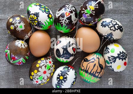 Modern colored Easter eggs according to Lithuanian tradition on a linen fabric background: natural brown, dyed and creatively decorated with figures Stock Photo