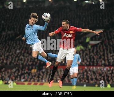 Manchester United's Rio Ferdinand (right) and Manchester City's David Silva (left) battle for the ball in the air Stock Photo