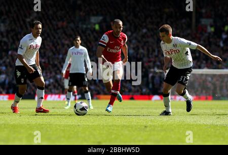 Arsenal's Theo Walcott (centre) breaks through pressure from Fulham's Kieran Richardson (left) and Alexander Kacaniklic (right) Stock Photo