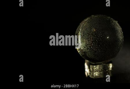 Crystal Ball on Pedestal with Water Droplets, Black Background Stock Photo