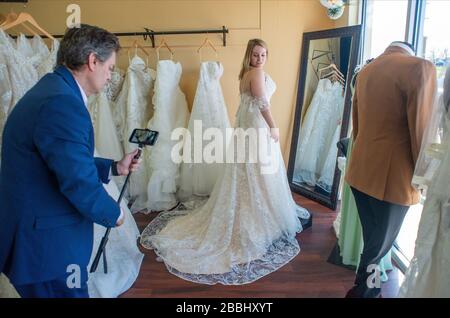 Franco Salerno (left) and Daria Capaldi videotape a dress for an online customer  during a shopping session with a customer Friday, March 27, 2020 at Stock Photo