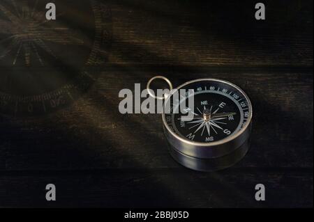 compass on a dark wooden background with rays of light Stock Photo
