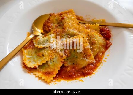 Spinach ravioli with a tomato sauce and Parmesan cheese Stock Photo