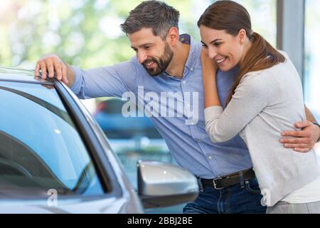 Young couple in the showroom, choosing a car Stock Photo