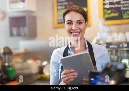 Woman working in coffee shop Stock Photo