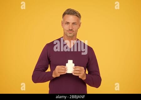 Body odor care. Handsome man hold lotion or bodywash bottle. Presenting personal hygiene care product. Shampoo or gel for hair care. Skin and body care. Cologne or deodorant, copy space. Stock Photo