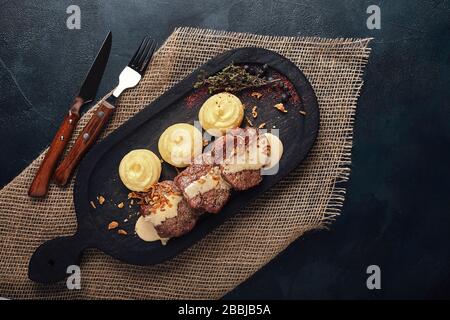 Meatloaf with french fries and vegetables on a wooden board, traditional English food. Food photo, copy space. Stock Photo