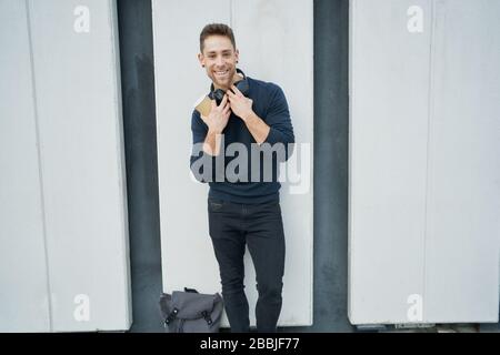modern man in casual clothes near a white wall with headphones and cof Stock Photo