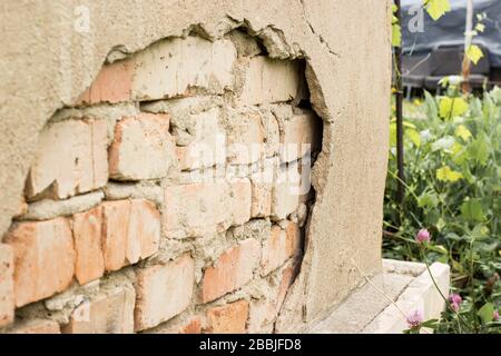 Non technology plaster. Building cracked plaster facade wall with brick. Stock Photo