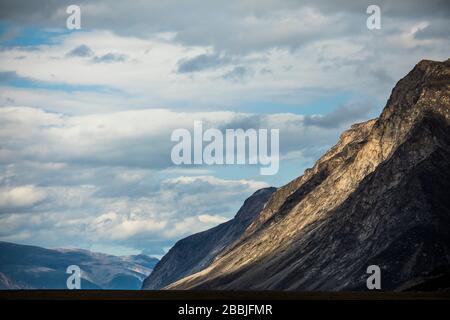 Sunlight shines on Baffin Island Mountains in Auyuittuq National Park Stock Photo