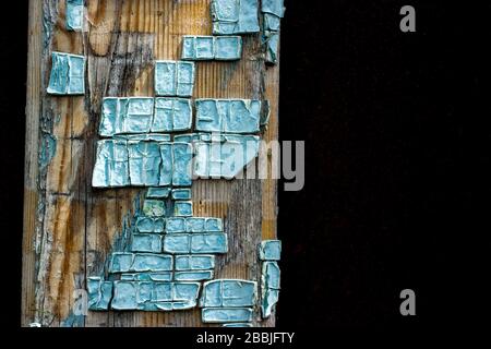 Part of old wooden boards painted in light blue cracked paint with several layers of shelled paint pieces Stock Photo