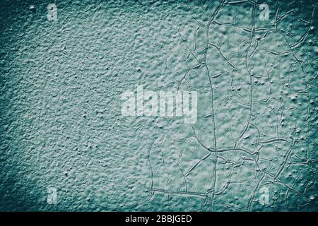 Surface of the old metal wall is covered with a lot of cracks, in which a rusty metal base is visible. Destruction of the old blue cracked paint Stock Photo