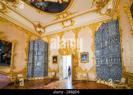 Inside one of the grand palatial rooms with gold trim and artwork on the ceilings in Catherine Palace in Pushkin Russia. Stock Photo