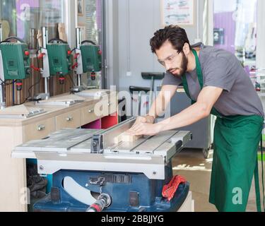 Handmade and craft furniture concept: Carpenter engaged in processing wood at the sawmill Stock Photo