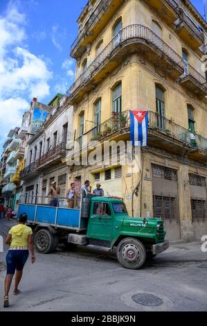 Work truck and building and flag at Brasil and Aguacate, Havana, Cuba Stock Photo