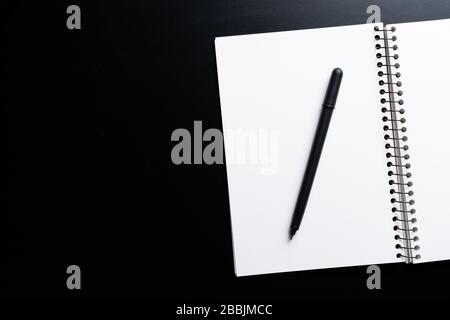 Black style set: notepad and pen on Black background. Stock Photo