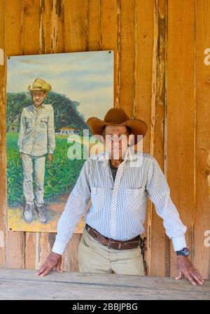 Farm worker with portrait of himself,  at organic farm, Vinales, Pinar del Rio Province, Cuba Stock Photo