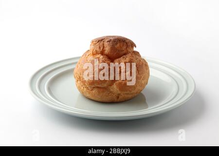 cream puff on plate closeup isolated on white background Stock Photo