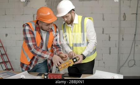 Young architects checking equipment on construction site Stock Photo