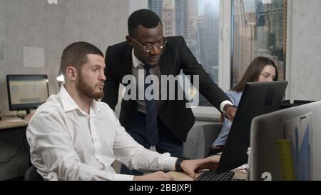 Coworkers discuss a problem in the office, solve it Stock Photo
