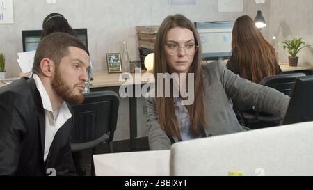 Young woman discussing work with her coworker Stock Photo
