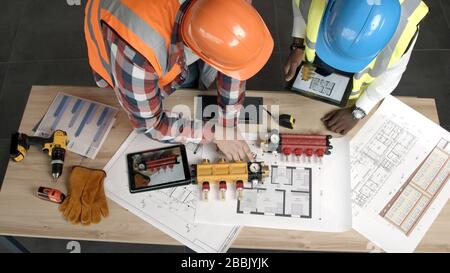 Young architects inspect new blueprints and equipment Stock Photo