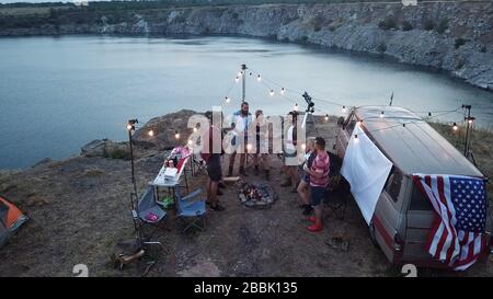 Friends Having Rest in Campsite Having Drinks Stock Photo