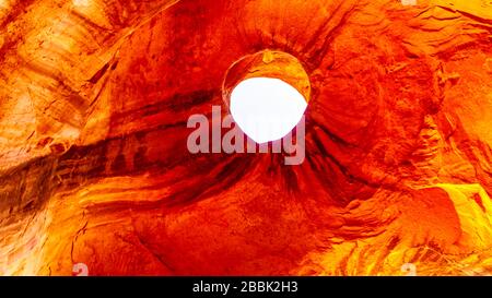 A hole in the ceiling of Big Hogan Arch, a large arch in Monument Valley Navajo Tribal Park on the Utah and Arizona border, USA Stock Photo