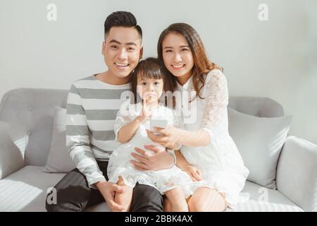 Happy family with children using mobile apps together at home Stock Photo