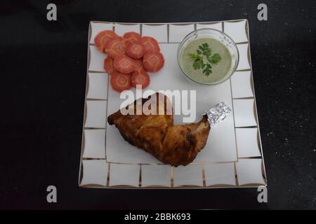 Homemade baked chicken tikka with fresh carrots and mint sauce Stock Photo