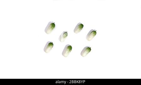 Small green cucumbers pattern with shadow isolated on white background. Natural healthy foodon table. Eco vegetable concept for market. Stock photo. Stock Photo