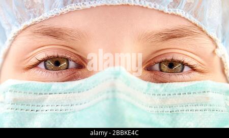The child in a medical mask and safety cap. Coronavirus protection. Closeup Stock Photo