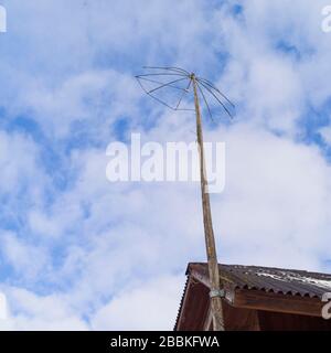 Old fashioned analogue TV antenna against the sky, low angle shot Stock Photo