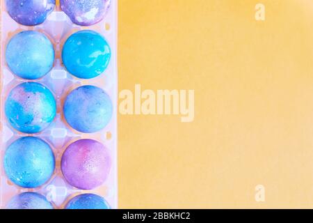 Painted Easter eggs with space intergalactic pattern in stand on yellow background Stock Photo