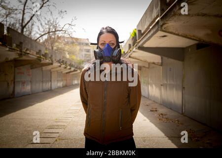 Woman is wearing industrial mask with paper filter her face for protection against virus COVID-19, Corona. Stock Photo