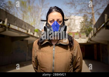 Woman is wearing industrial mask with paper filter her face for protection against virus COVID-19, Corona. Stock Photo