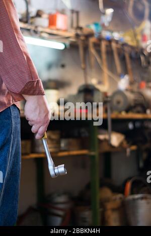 Man's hand holding a socket wrench with ratchet in the garage Stock Photo