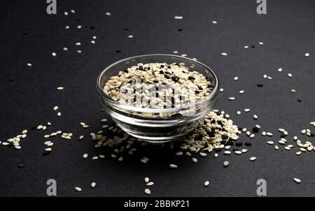 Black and white sesame seeds on black background, macro, close up Stock Photo