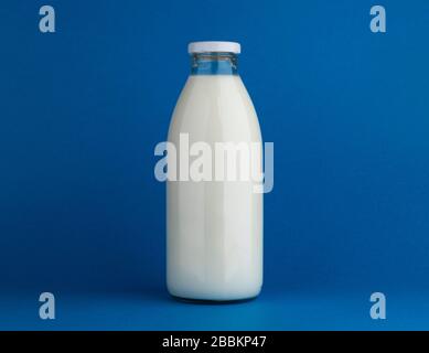 Glass milk bottle mock up on blue background Stock Photo