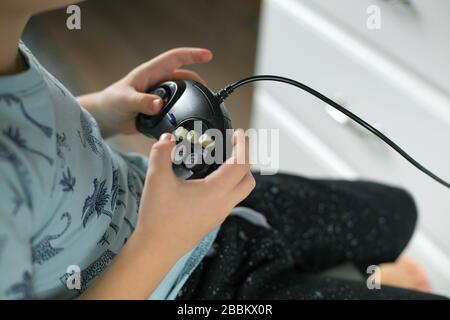 Boy playing video games at home. Family staying at home. Self isolation. Corona virus epidemic, quarantine Stock Photo