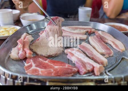 delicious grilled pork barbecue, meat are being cooked on stove. Stock Photo