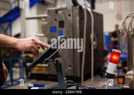 Repairman doing maintenance on the mold injection for plastic components, industrial concept Stock Photo