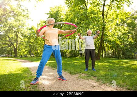 Senior Couple Exercising In Park Stock Photo