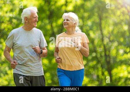 Senior Couple Exercising In Park Stock Photo