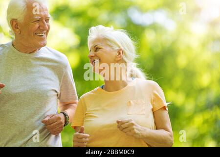 Senior Couple Exercising In Park Stock Photo
